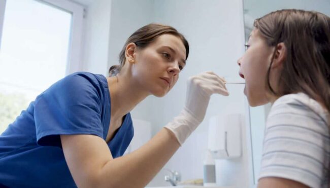 Clinician performing throat swab for strep test