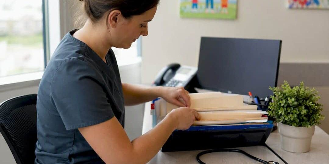 1787000507750_Clinic-receptionist-sorting-immunization-records Clinic receptionist sorting immunization records