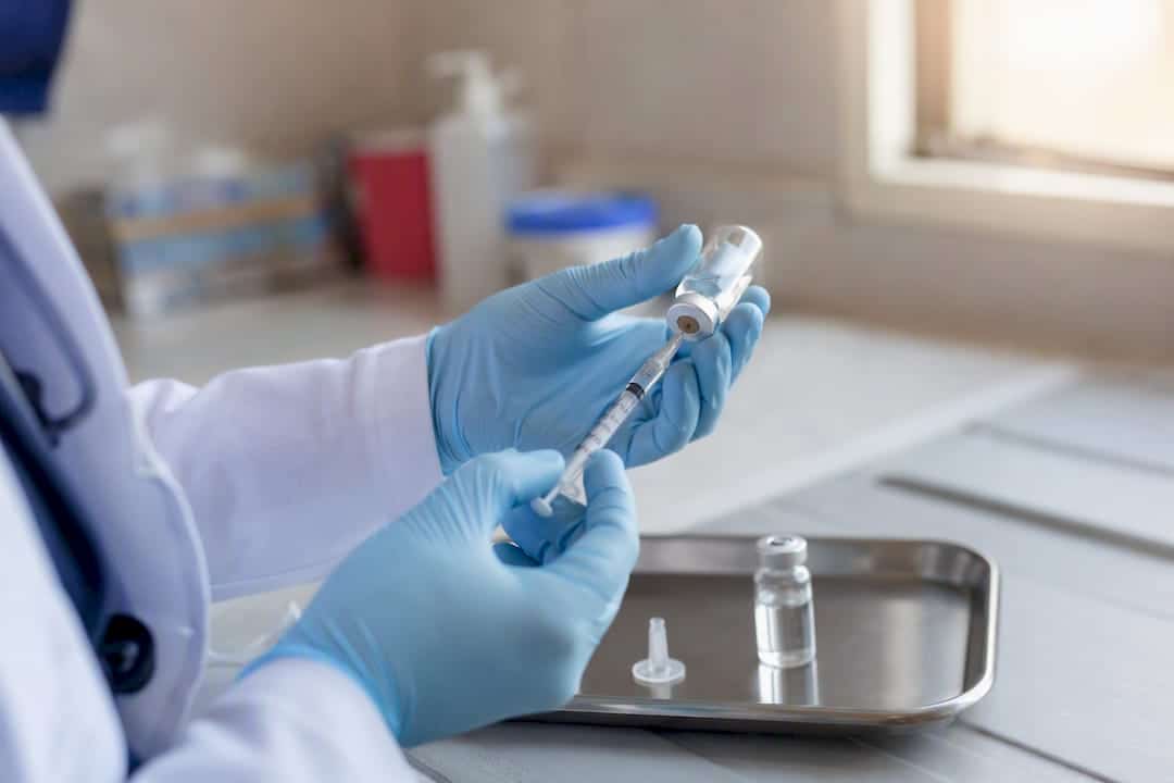 Syringe and vaccine vial in clinical setting