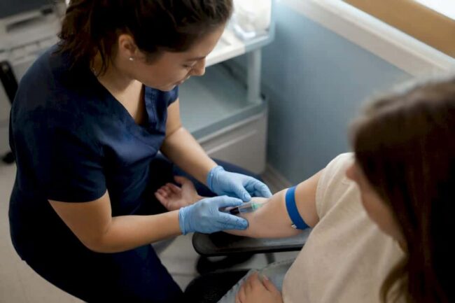 Nurse drawing blood for herpes test