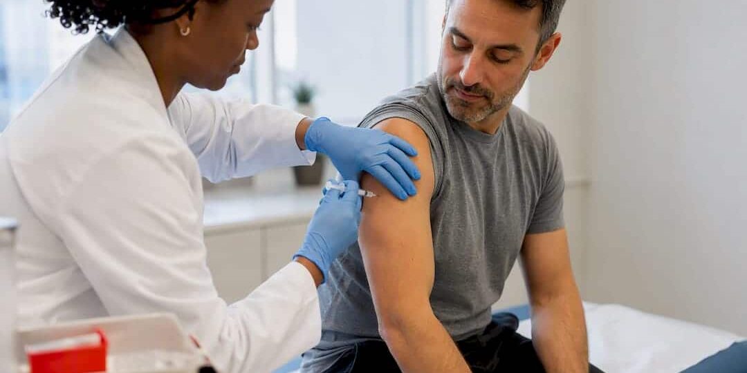 1788602549362_Clinician-administering-a-flu-vaccination Clinician administering a flu vaccination