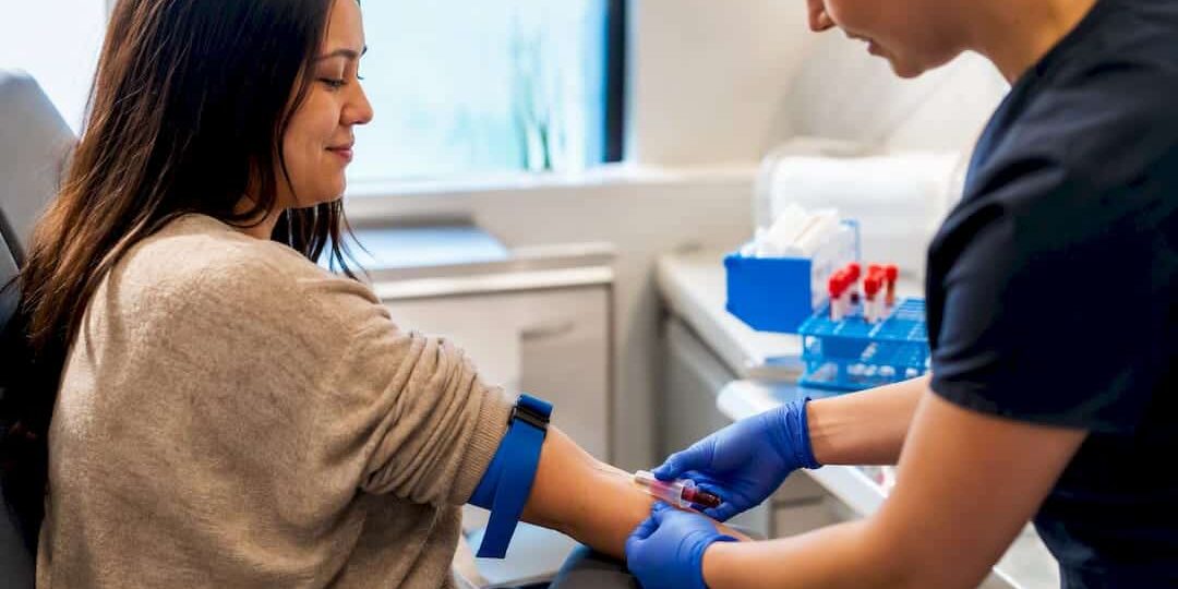 1788811322523_Clinician-drawing-blood-from-fasting-patient Clinician drawing blood from fasting patient
