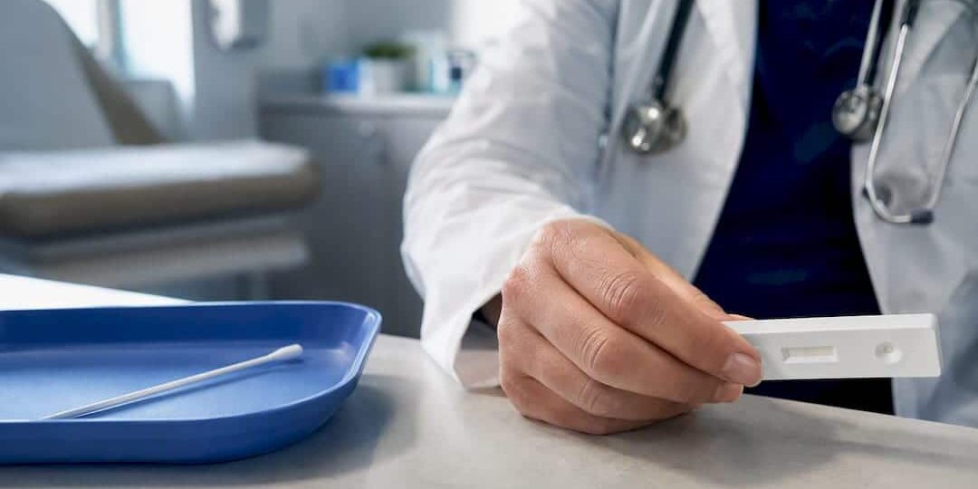 1789293725543_Clinician-reviewing-rapid-flu-test-result Clinician reviewing rapid flu test result