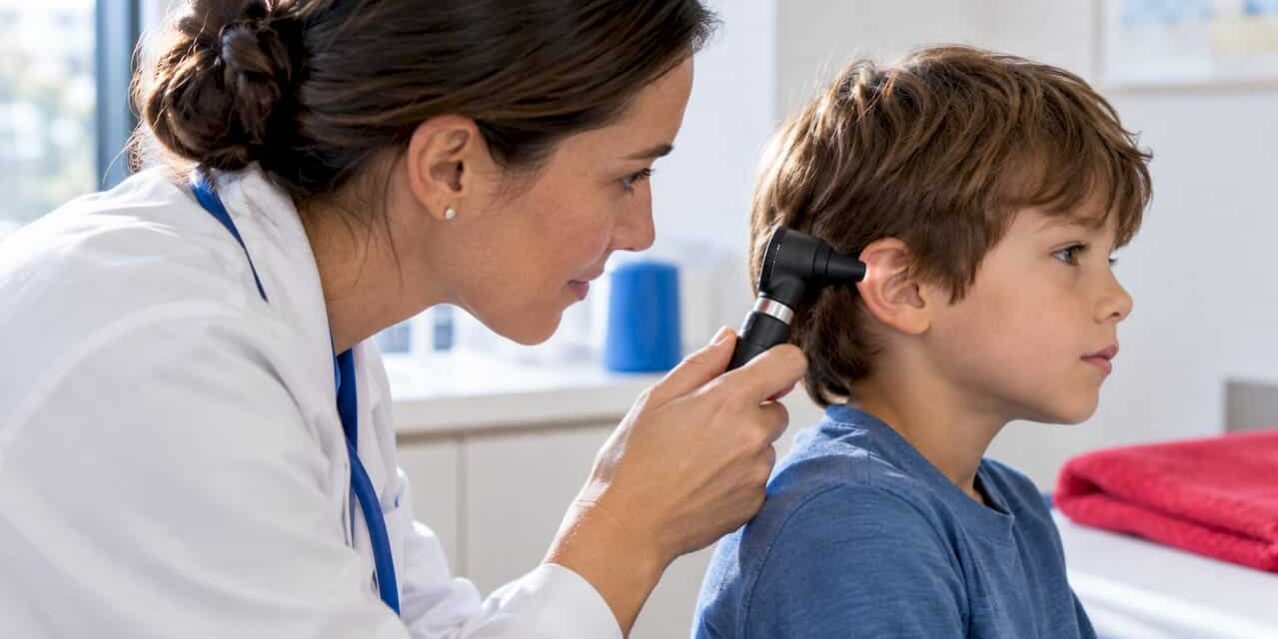 1789722538709_Clinician-examining-child-s-ear-with-otoscope Clinician examining child’s ear with otoscope
