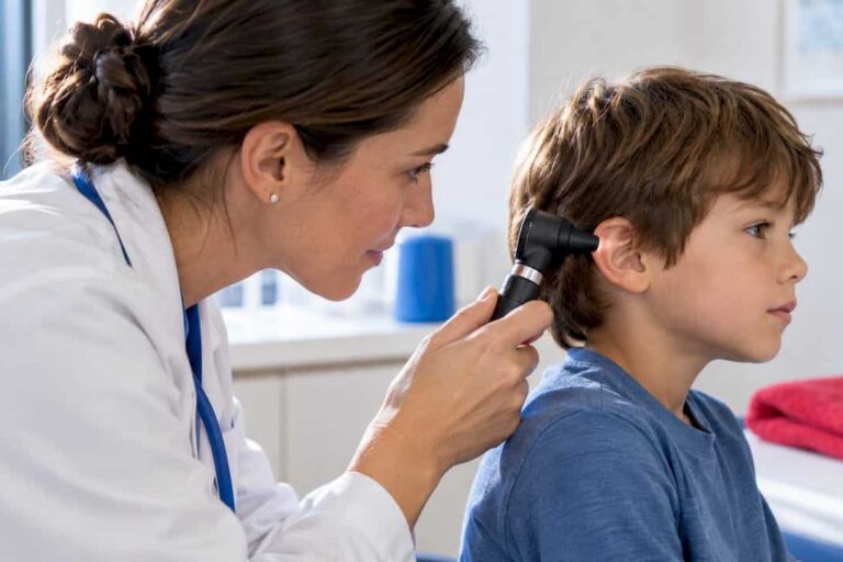 Clinician examining child’s ear with otoscope
