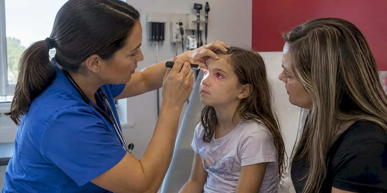 Clinician assessing child's red eye with parent