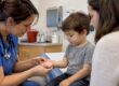 Clinician examining child’s HFMD palm rash