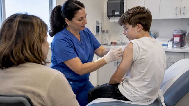 Nurse giving a vaccine to a teen
