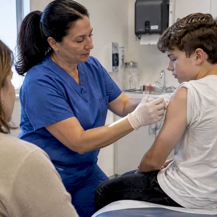 Nurse giving a vaccine to a teen