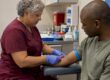 Clinician collecting a blood sample during screening