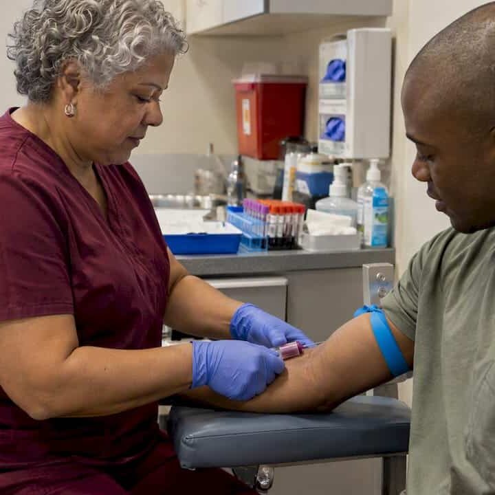 Clinician collecting a blood sample during screening