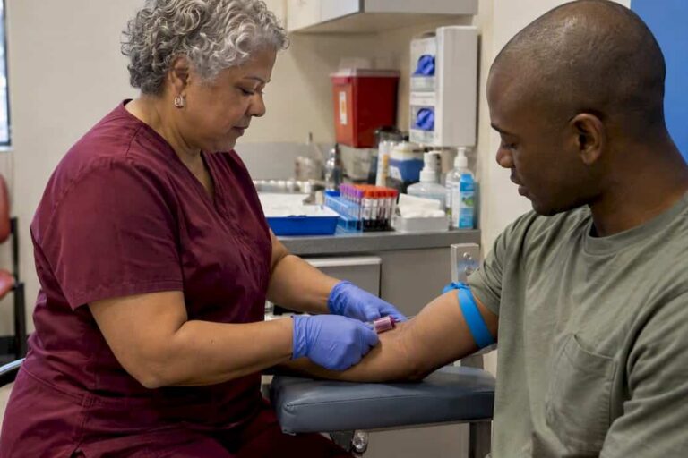 Clinician collecting a blood sample during screening